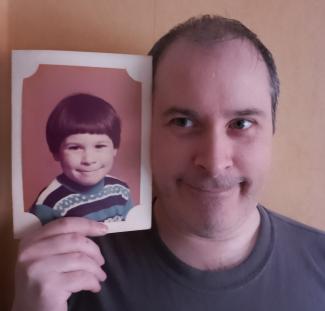 Posing with one of my primary school portraits... wearing the same non-smile, but without such a jazzy jumper.